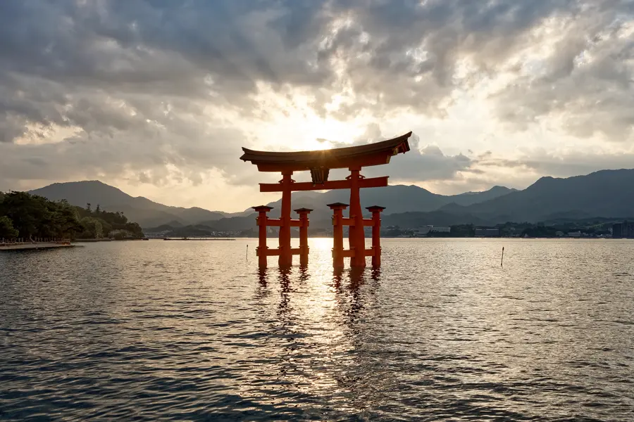 The red torii of Itsukushima standing in the water at sunset